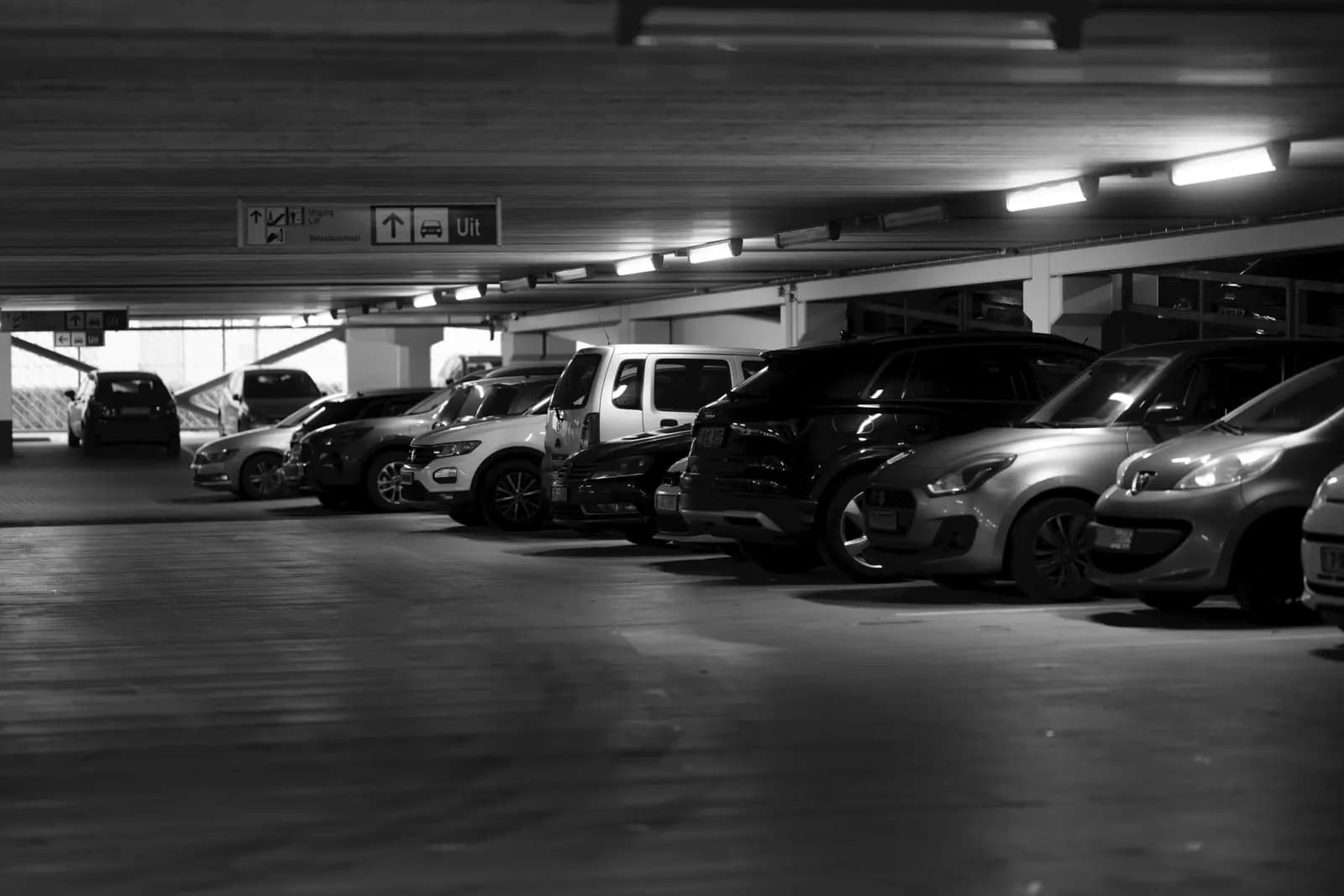 Parking aéroport couvert de nuit avec éclairage et places de stationnement